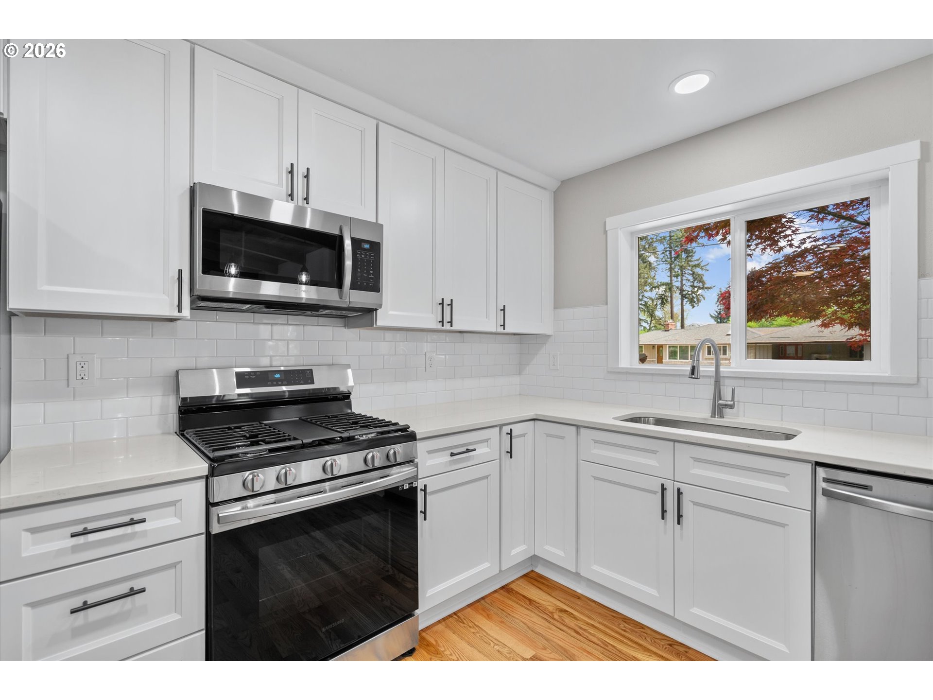 11345 Southwest 92nd Avenue Portland, OR 97223 - Photo 13 of 47 a kitchen with stainless steel appliances a stove microwave and sink