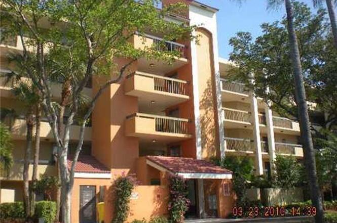 2025 Lavers Circle, Unit D207 Delray Beach, FL 33444 - Photo 11 of 12 front view of a building with a tree