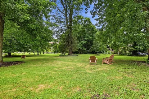 an aerial view of a house with a yard and large trees
