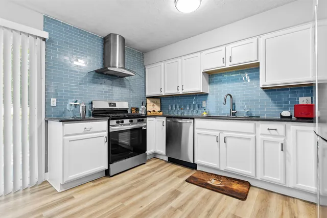 a kitchen with granite countertop white cabinets and white appliances