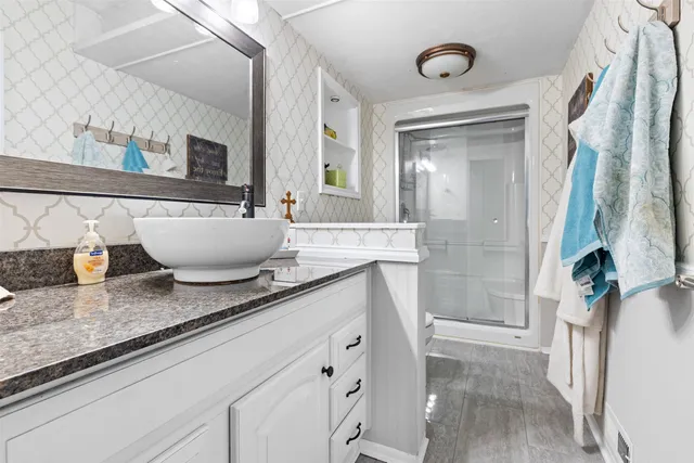 a spacious bathroom with a granite countertop sink and a mirror