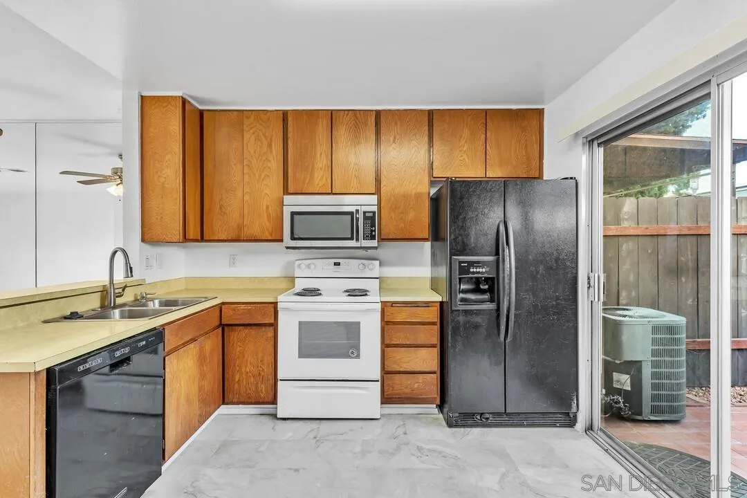 10258 Carefree Drive Santee, CA 92071 - Photo 10 of 30 a kitchen with stainless steel appliances wooden cabinets a sink and a refrigerator