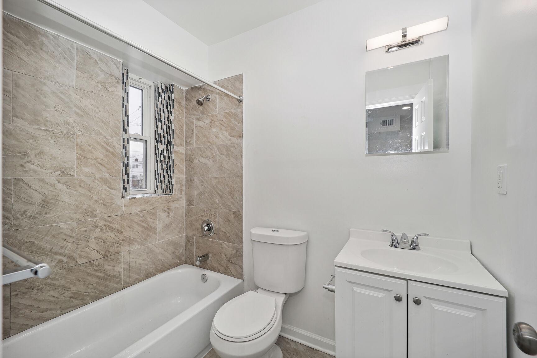 1642 16th Street Southeast, Unit 3 Washington, DC 20020 - Photo 22 of 22 a bathroom with a toilet sink vanity tub and shower
