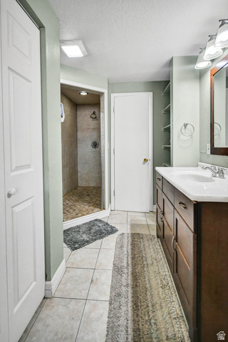 10 North Main Street Centerfield, UT 84622 - Photo 23 of 52 Full bathroom featuring light tile patterned floors, a textured ceiling, a stall shower, and vanity