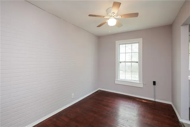 an empty room with wooden floor and window