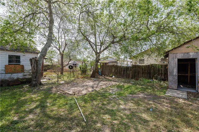 a backyard of a house with barbeque oven table and chairs