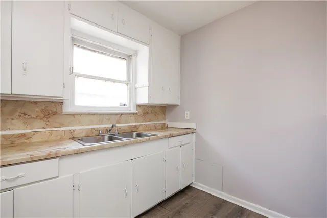 a kitchen with a sink cabinets appliances and a window