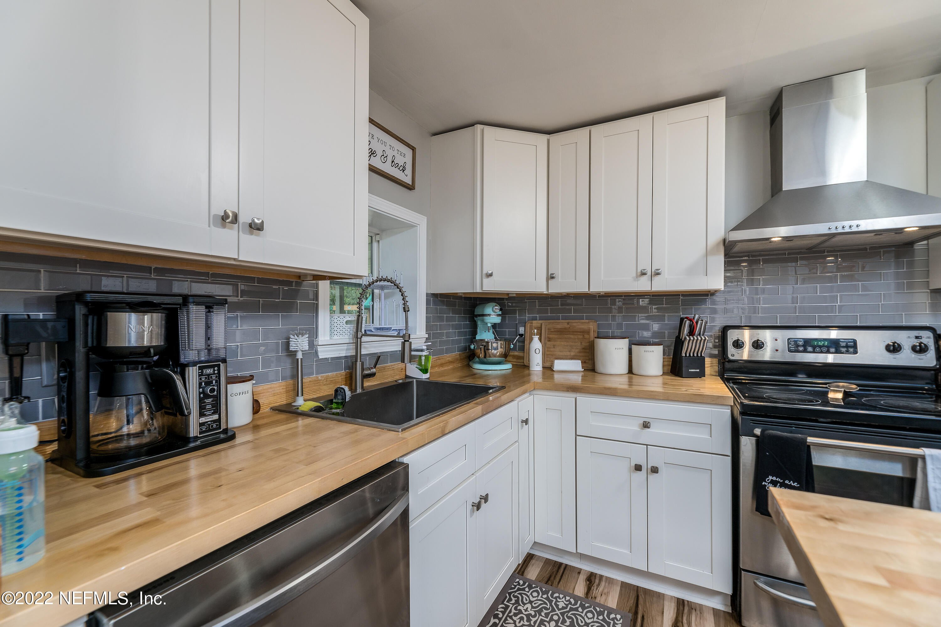 5807 Ricker Road Jacksonville, FL 32244 - Photo 14 of 31 a kitchen with stainless steel appliances granite countertop a stove and a white cabinets