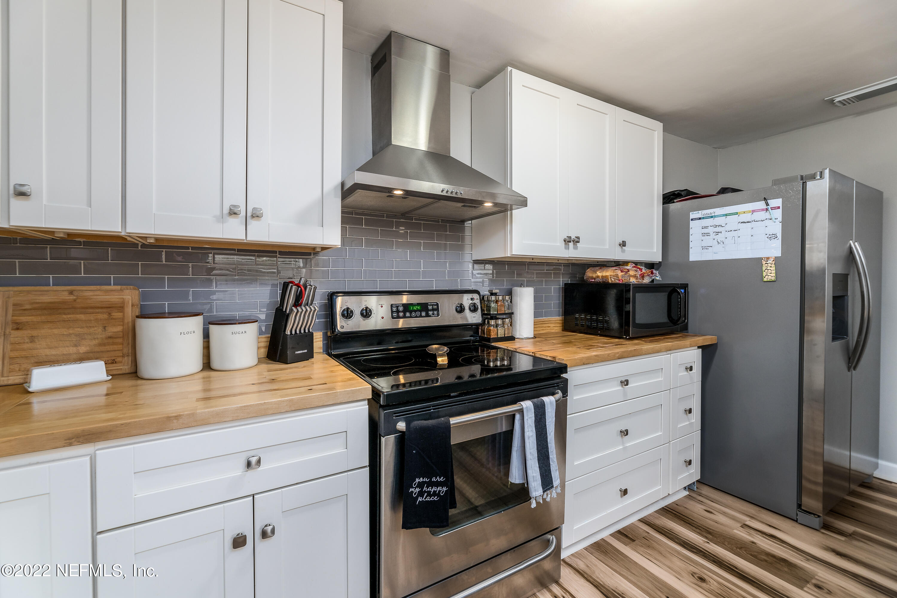 5807 Ricker Road Jacksonville, FL 32244 - Photo 15 of 31 a kitchen with stainless steel appliances granite countertop a stove a refrigerator and a white cabinets