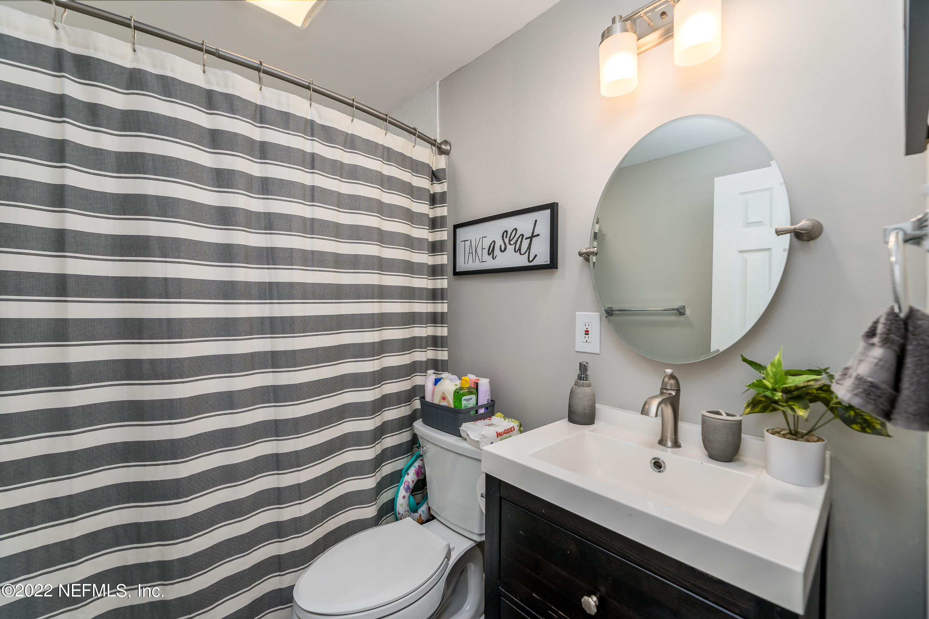 5807 Ricker Road Jacksonville, FL 32244 - Photo 23 of 31 a bathroom with a sink toilet and mirror