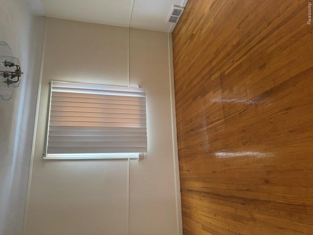 8144 Meyers Road Detroit, MI 48228 - Photo 8 of 19 Hardwood flooring complements neutral wall tones and a window with vertical blinds