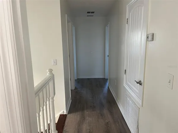 a view of a hallway with wooden floor and staircase