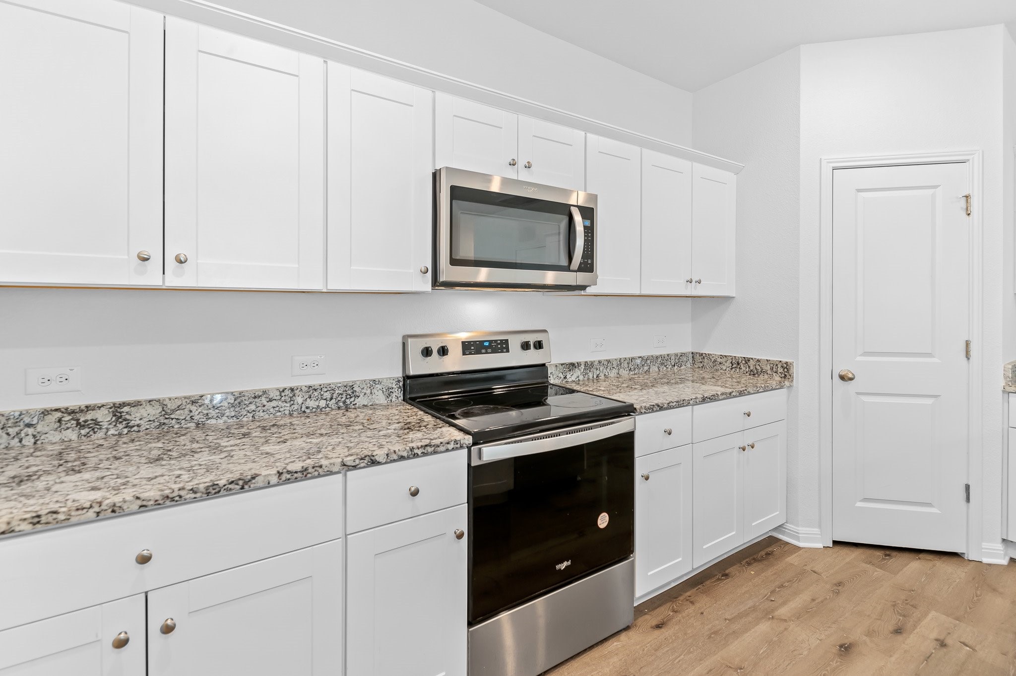224 Night Riders Way Jarrell, TX 76537 - Photo 13 of 40 a kitchen with granite countertop white cabinets and a stove