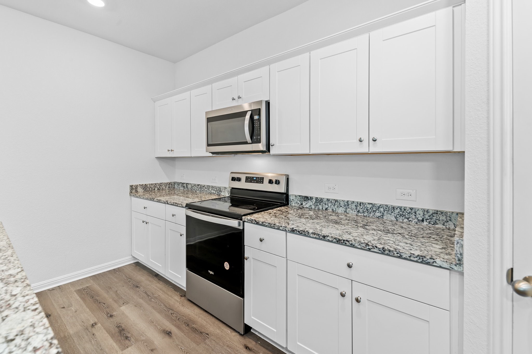 224 Night Riders Way Jarrell, TX 76537 - Photo 14 of 40 a kitchen with granite countertop white cabinets and stainless steel appliances