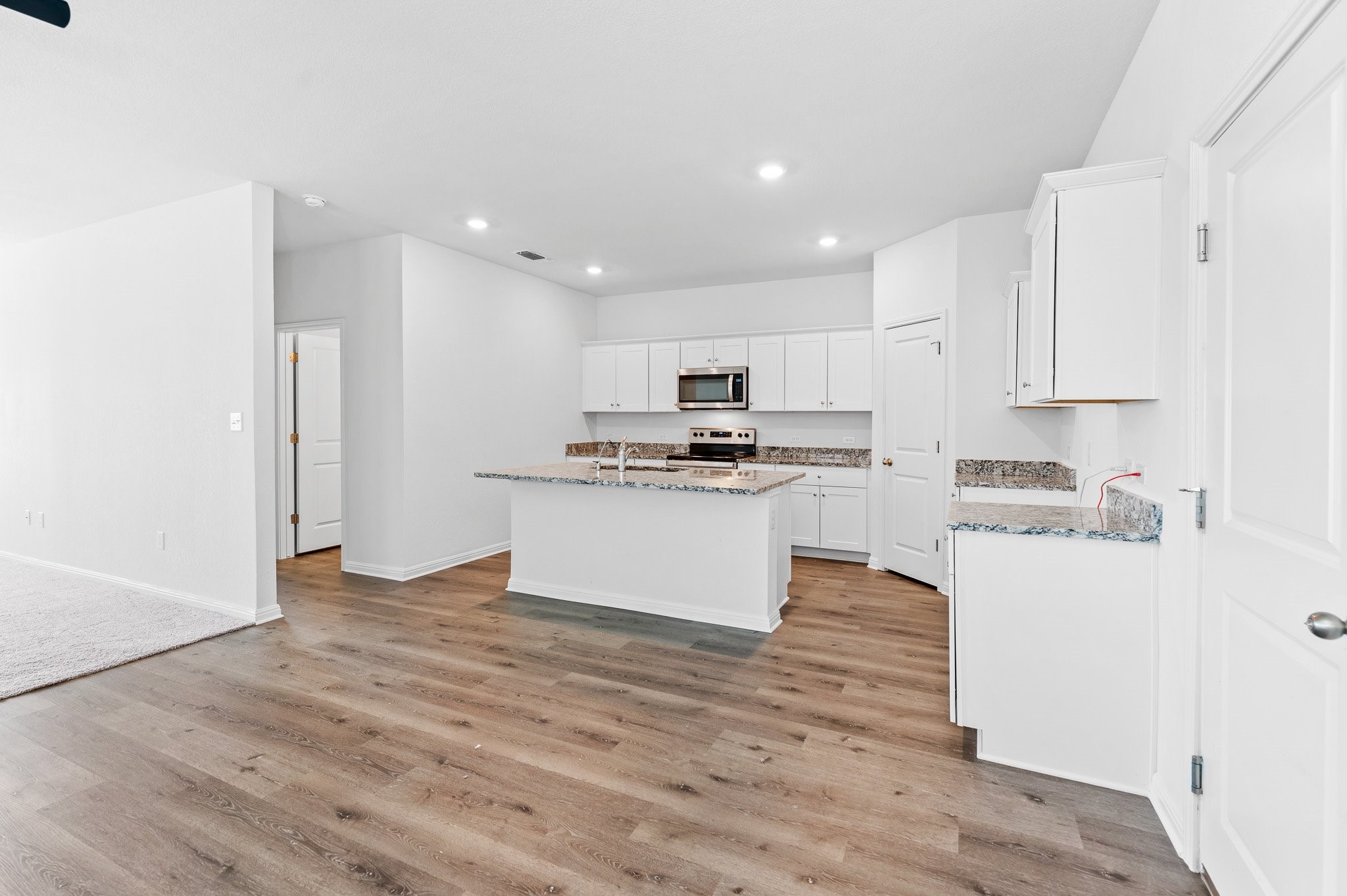 224 Night Riders Way Jarrell, TX 76537 - Photo 8 of 40 a kitchen with granite countertop white cabinets and stainless steel appliances