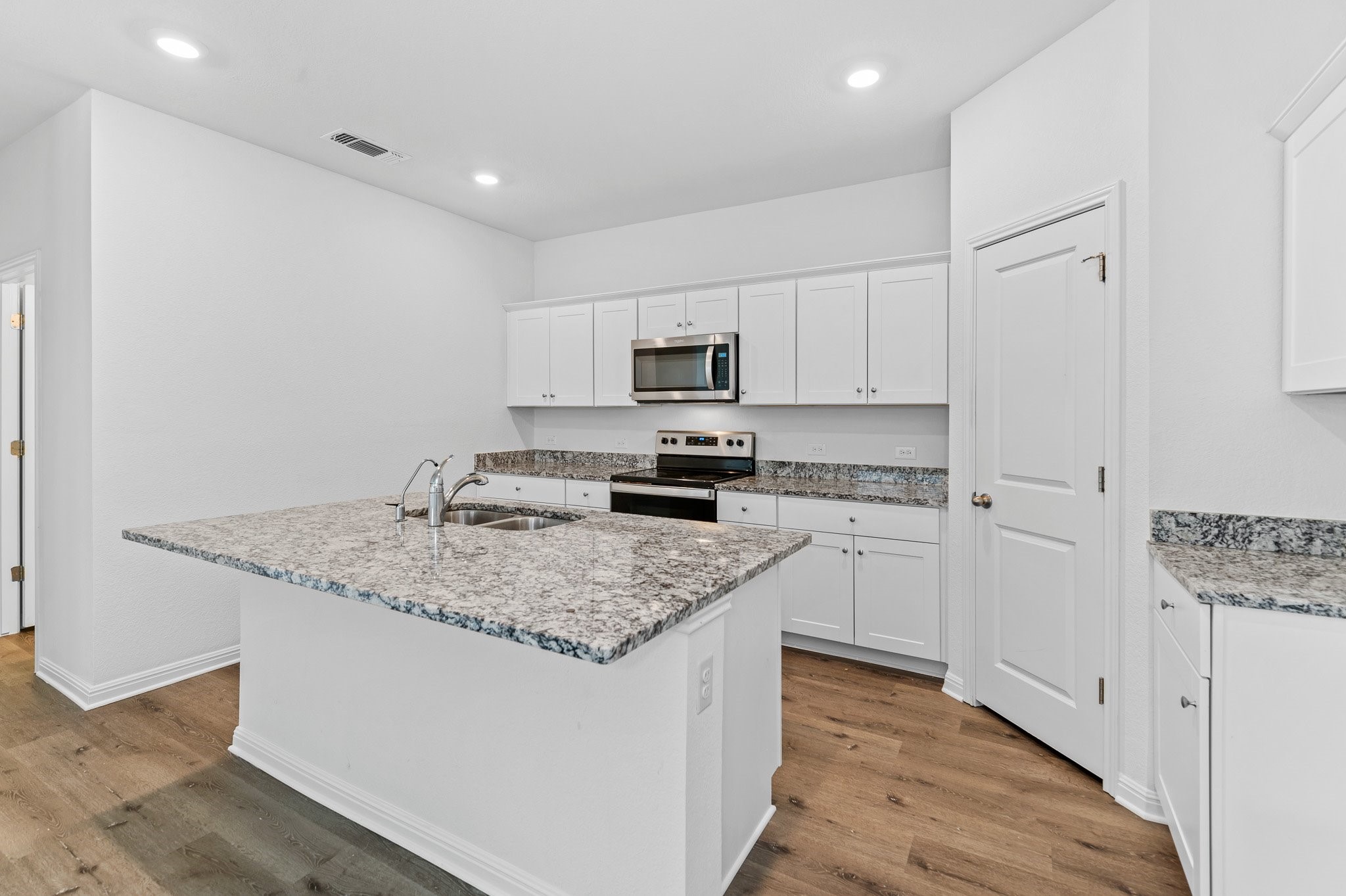 224 Night Riders Way Jarrell, TX 76537 - Photo 9 of 40 a kitchen with a sink a stove a microwave and cabinets