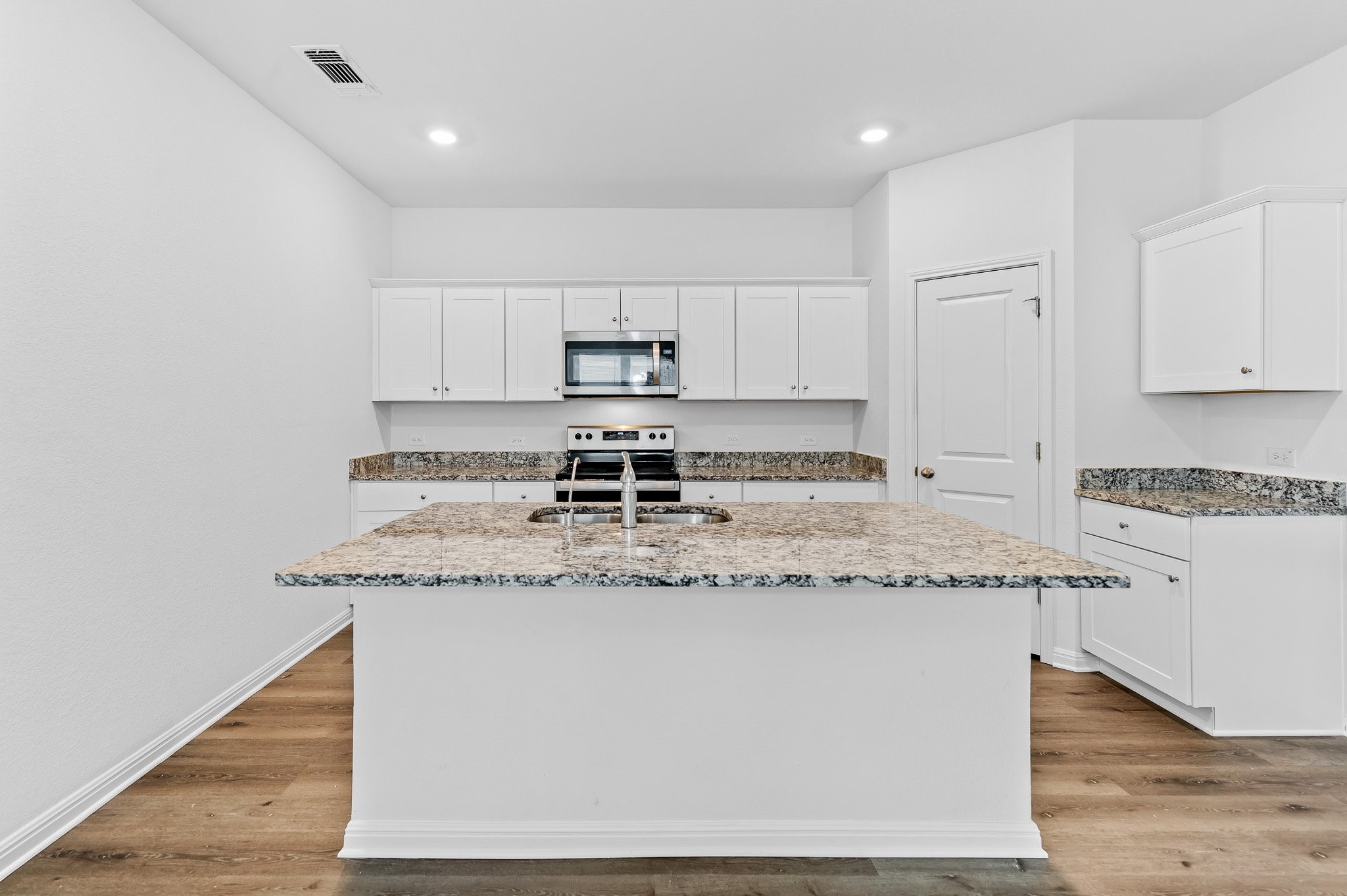224 Night Riders Way Jarrell, TX 76537 - Photo 10 of 40 a kitchen with stainless steel appliances granite countertop a sink a stove and white cabinets
