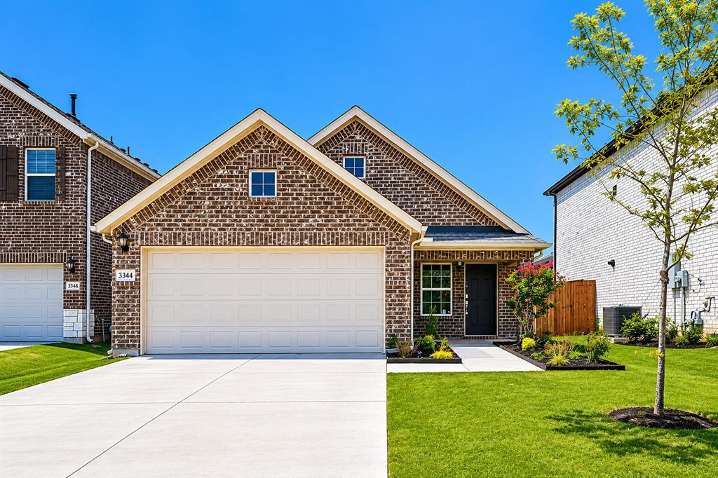 3344 Duncan Way Corinth, TX 76210 - Photo 1 of 38 Classic brick exterior featuring a front entry garage, dark entry door, and manicured landscaping