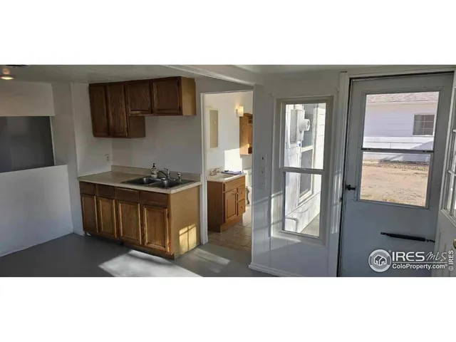 a kitchen view of a stove a refrigerator and a view of living room