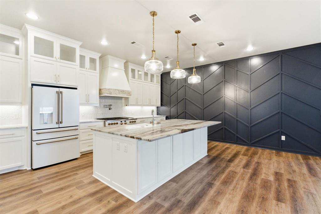 4600 B Old Brock Road Weatherford, TX 76087 - Photo 14 of 40 Kitchen featuring high end fridge, white cabinets, a decorative wall, light stone countertops, and pendant lighting