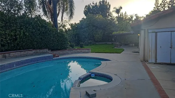 a view of backyard with swimming pool and outdoor seating