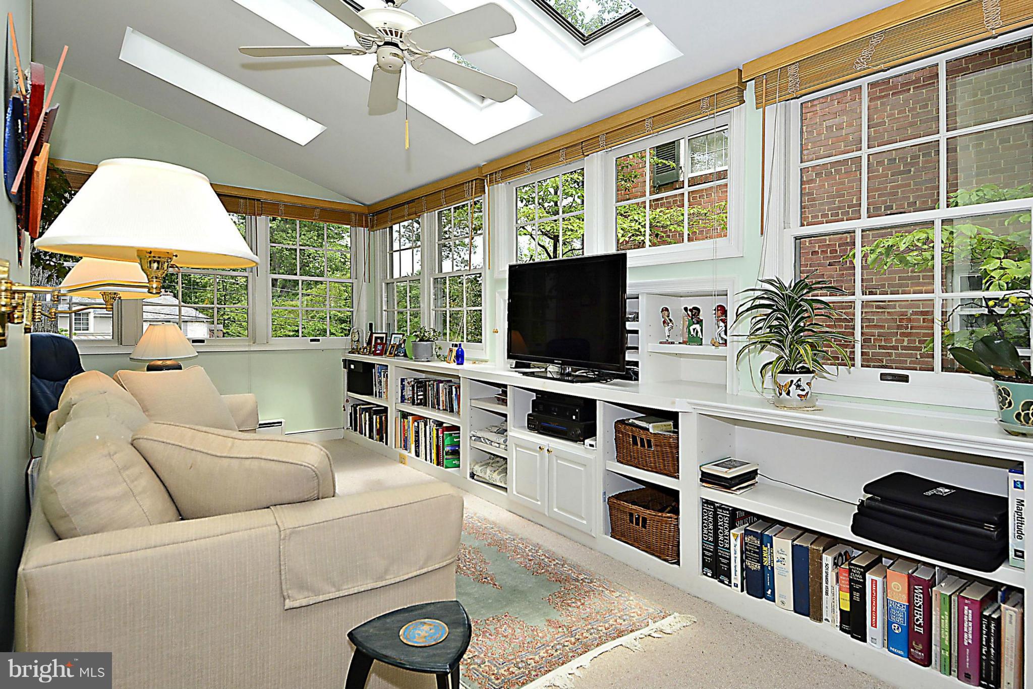 510 Ashford Road Silver Spring, MD 20910 - Photo 11 of 30 a living room with furniture a flat screen tv and a floor to ceiling window