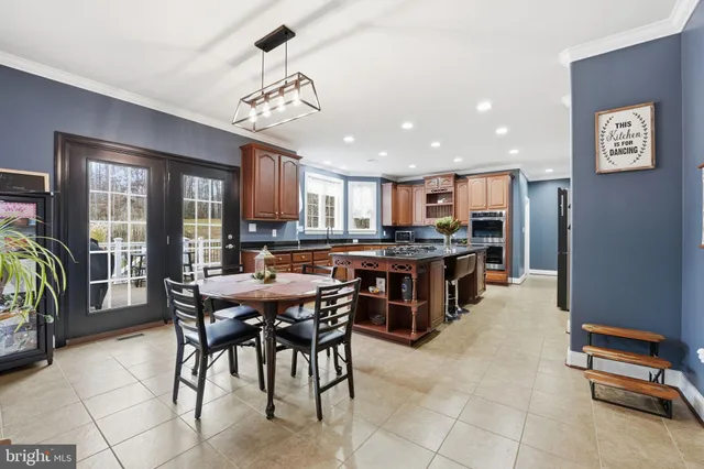 a kitchen with granite countertop a sink a counter top space stainless steel appliances and cabinets