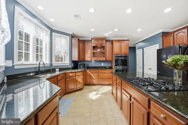 a kitchen with stainless steel appliances granite countertop a refrigerator and a sink