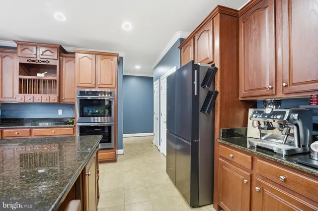 a kitchen with kitchen island granite countertop a sink counter and chairs