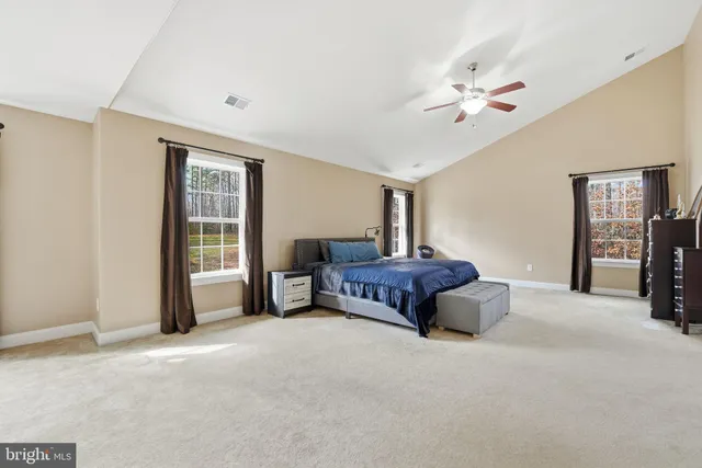 a spacious bedroom with a bed and a large window