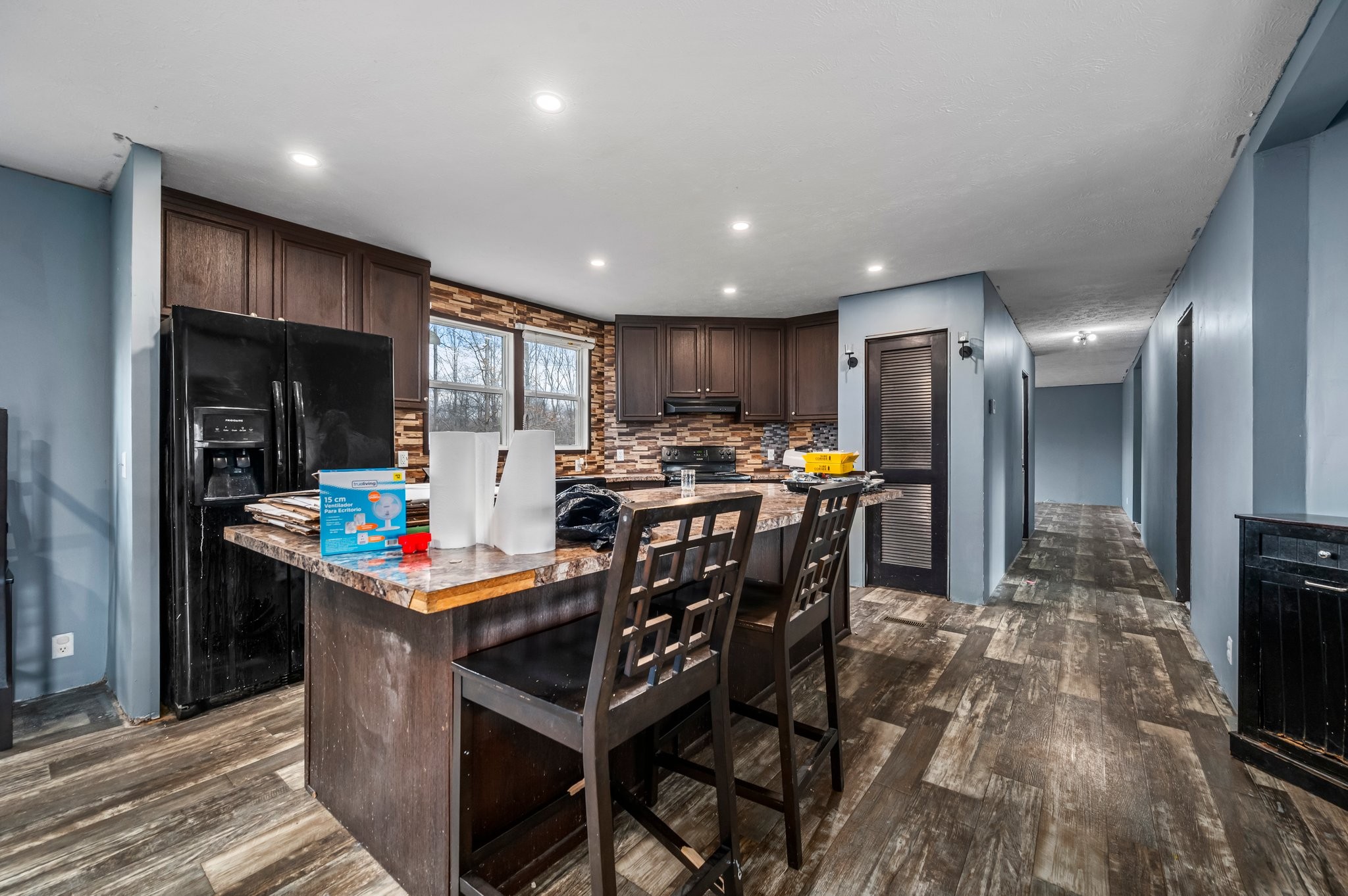 6684 Wesley Ridge Road Lyles, TN 37098 - Photo 12 of 37 a kitchen with stainless steel appliances kitchen island granite countertop a table chairs and a refrigerator