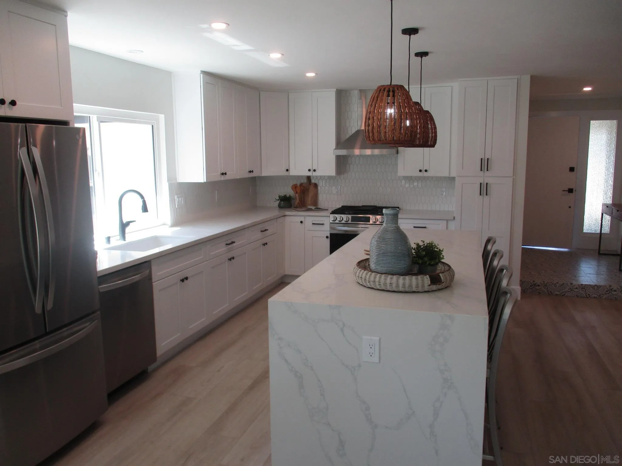 141 Solace Court Encinitas, CA 92024 - Photo 4 of 16 a kitchen with stainless steel appliances granite countertop a sink a refrigerator a stove a dining table and chairs