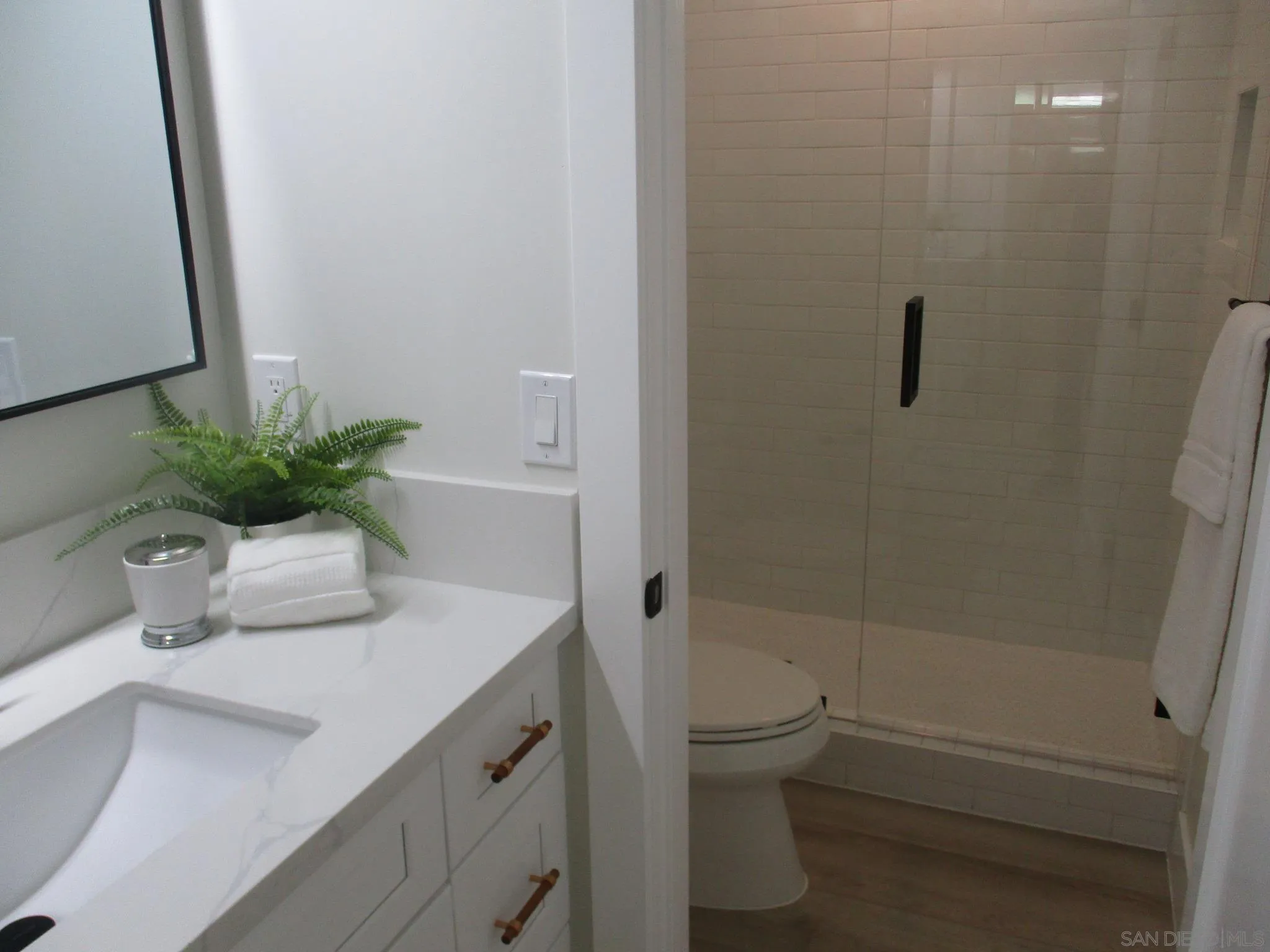 141 Solace Court Encinitas, CA 92024 - Photo 10 of 16 a bathroom with a shower curtain a sink a toilet and a mirror