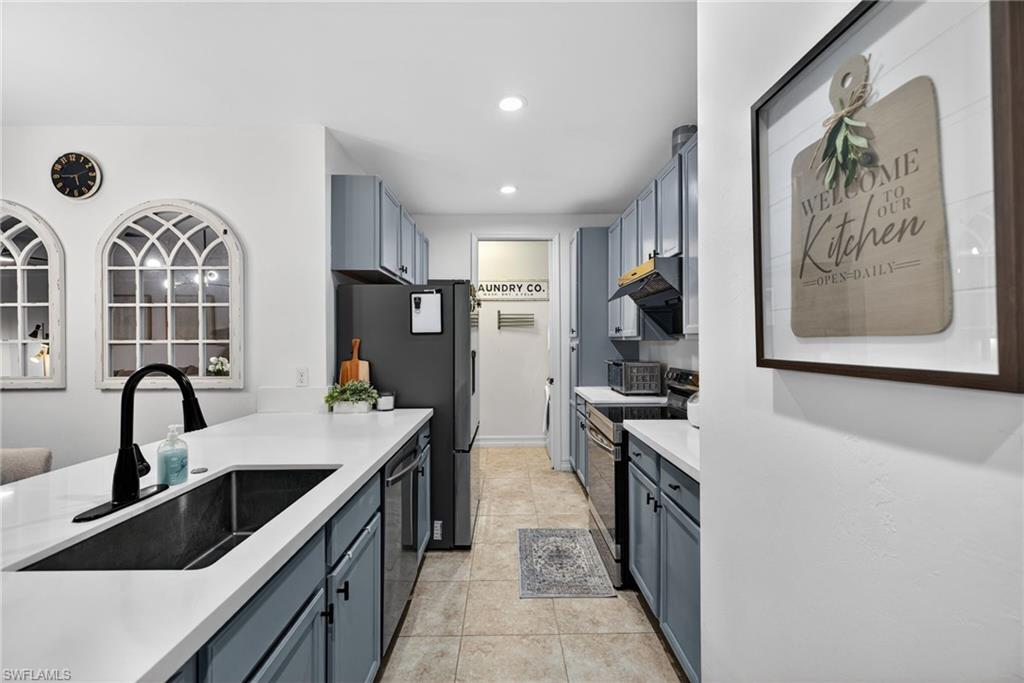 7845 Bristol Circle Naples, FL 34120 - Photo 11 of 31 a kitchen with stainless steel appliances a sink stove and refrigerator