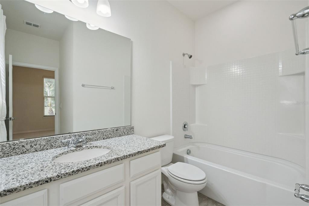 16031 Pebble Blf Loop Winter Garden, FL 34787 - Photo 23 of 51 a bathroom with a granite countertop sink a toilet and a bathtub