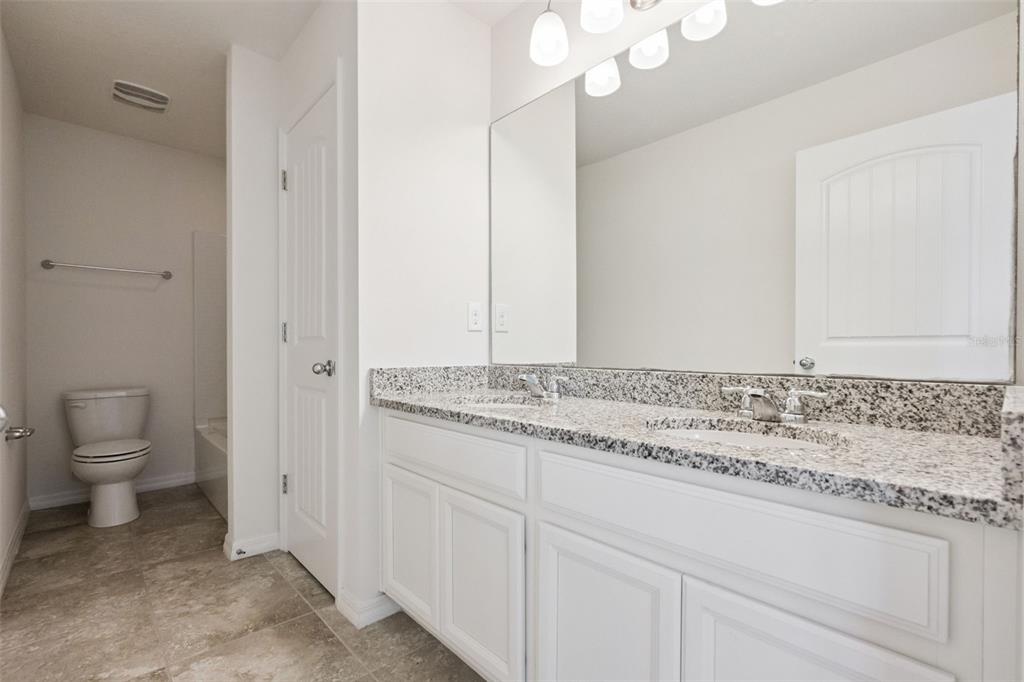 16031 Pebble Blf Loop Winter Garden, FL 34787 - Photo 26 of 51 a bathroom with a granite countertop sink and a toilet