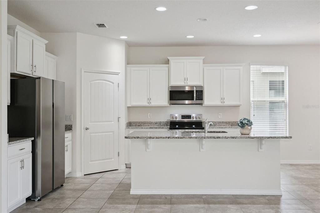 16031 Pebble Blf Loop Winter Garden, FL 34787 - Photo 7 of 51 a kitchen with stainless steel appliances granite countertop grey cabinets a refrigerator and a sink