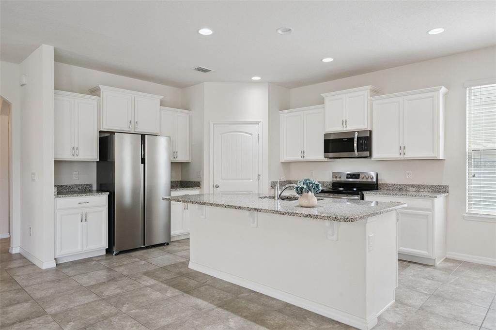 16031 Pebble Blf Loop Winter Garden, FL 34787 - Photo 8 of 51 a kitchen with stainless steel appliances granite countertop a sink a stove a refrigerator a microwave and cabinets