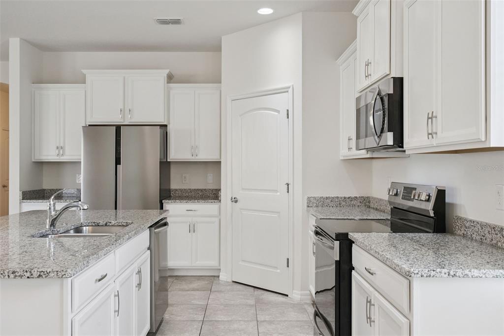16031 Pebble Blf Loop Winter Garden, FL 34787 - Photo 9 of 51 a kitchen with stainless steel appliances granite countertop a sink stove and refrigerator