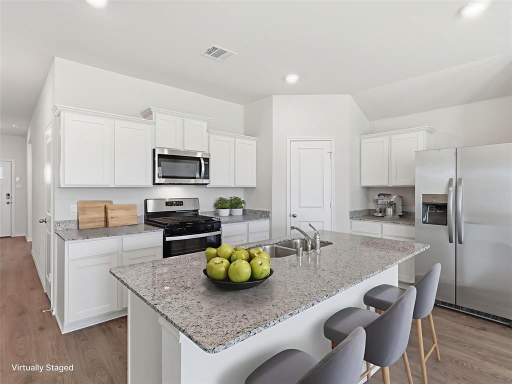 757 Tiger Lily Way Pilot Point, TX 76258 - Photo 4 of 16 a kitchen with granite countertop stainless steel appliances and wooden cabinets