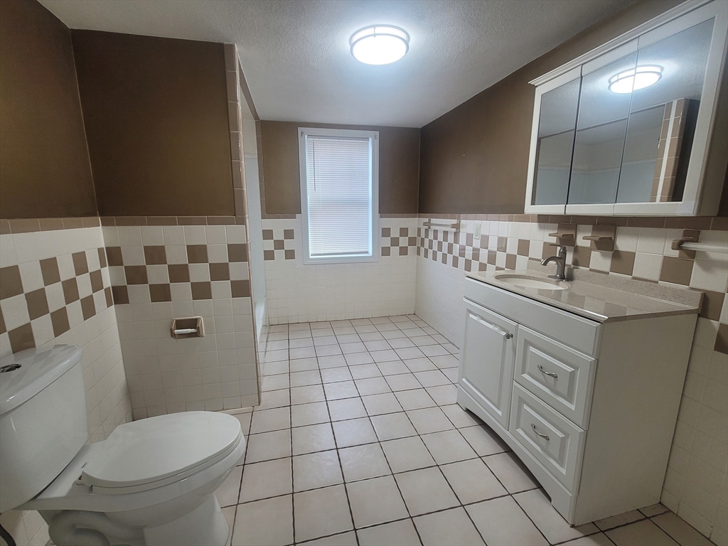 237 Colburn Street, Unit 237 Dedham, MA 02026 - Photo 12 of 16 a bathroom with a toilet sink and mirror