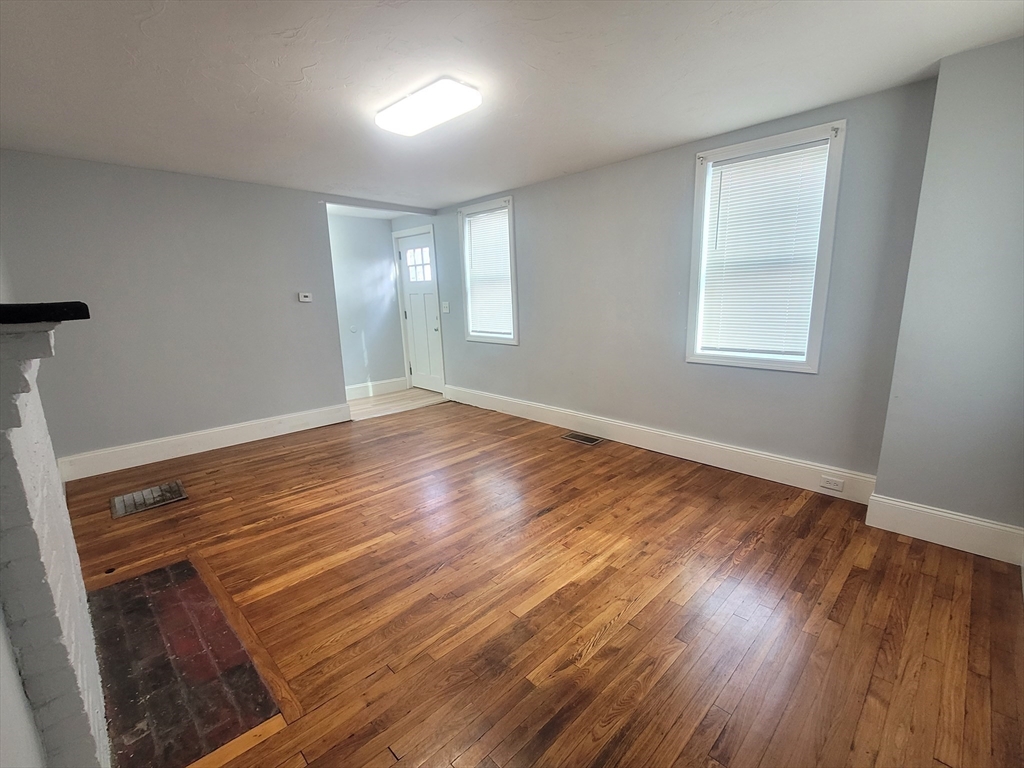 237 Colburn Street, Unit 237 Dedham, MA 02026 - Photo 4 of 16 a view of an empty room with wooden floor and a window