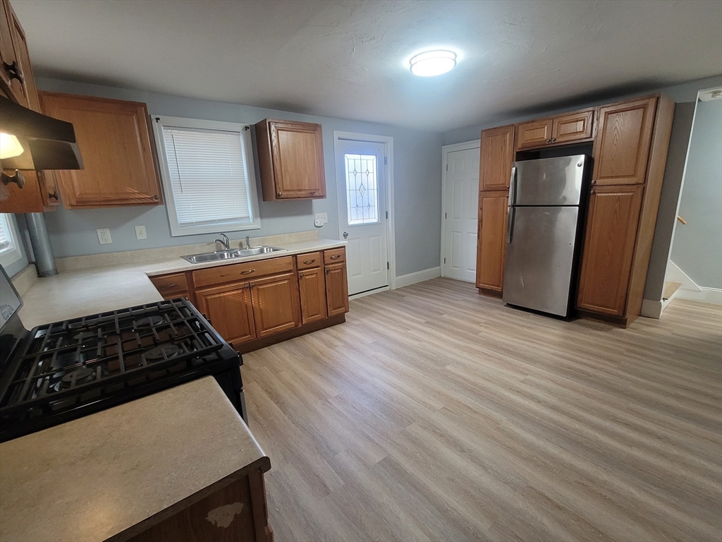 237 Colburn Street, Unit 237 Dedham, MA 02026 - Photo 7 of 16 a kitchen with granite countertop a stove and a refrigerator