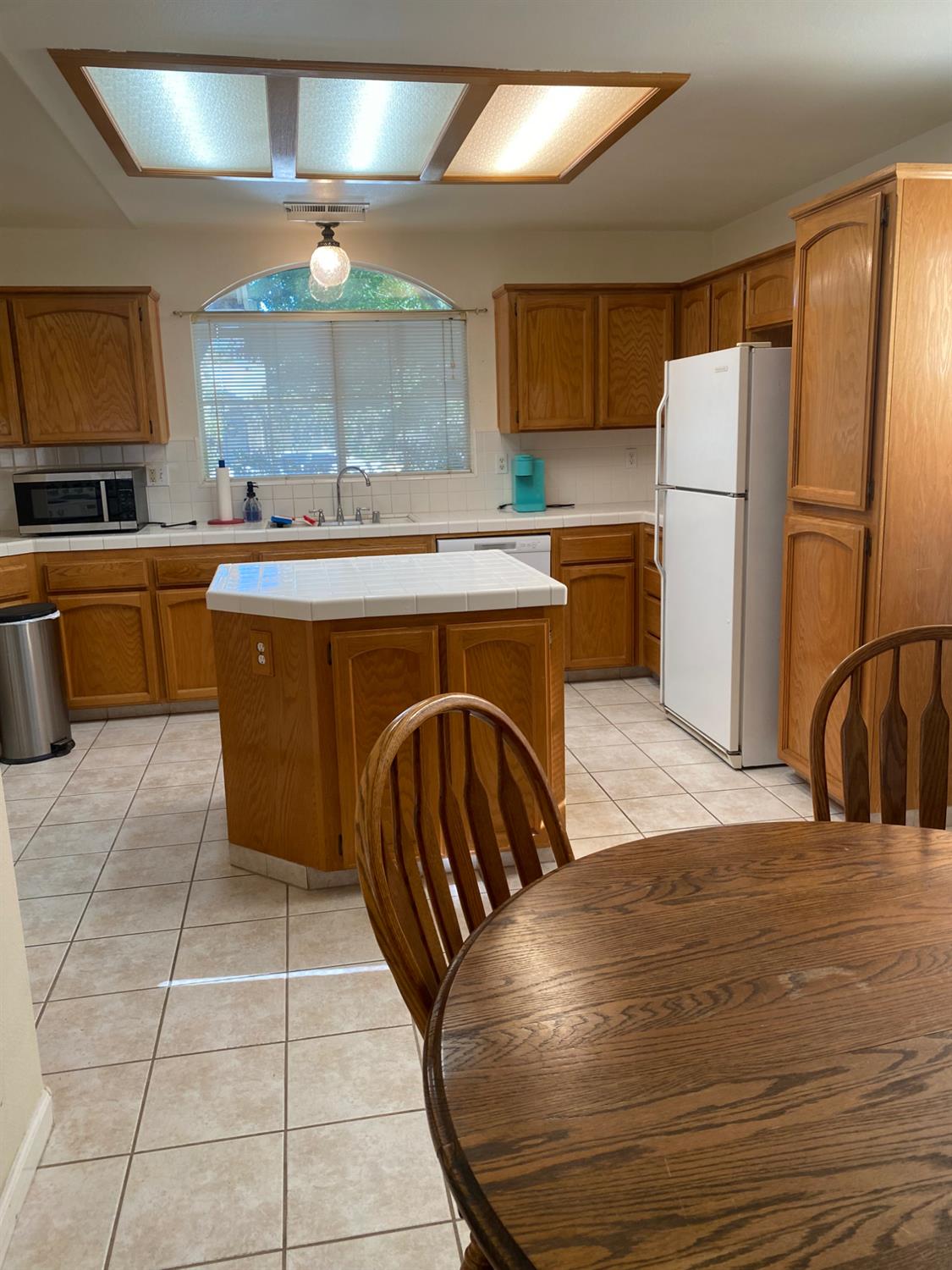 609 Merlot Avenue Madera, CA 93637 - Photo 14 of 45 a kitchen with stainless steel appliances granite countertop a sink a stove a refrigerator a washer and dryer with wooden cabinets