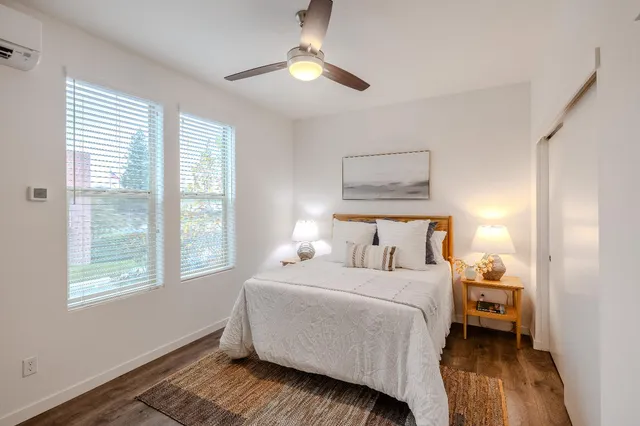 a bedroom with a bed wooden floor and a window