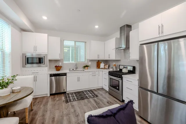 a kitchen with white cabinets and stainless steel appliances