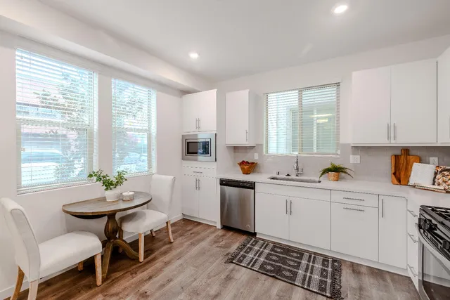 a kitchen with a white cabinets and chairs