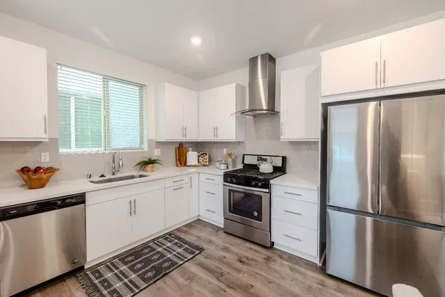 a kitchen with stainless steel appliances a refrigerator sink and cabinets