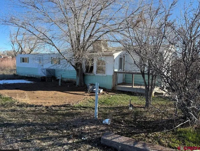a view of a house with a yard covered in snow