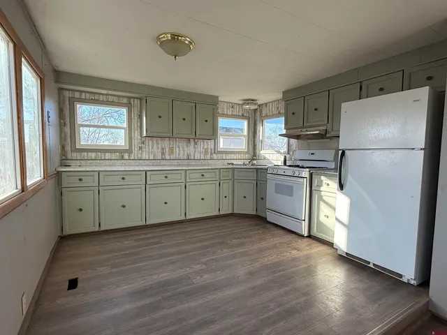 a kitchen with stainless steel appliances granite countertop a refrigerator a sink a stove a microwave a counter space and cabinets